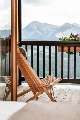 a wooden porch with a view of the mountains at La Majun Fornellahof in Antermoia