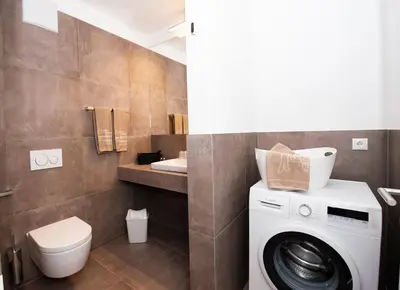 a bathroom with a washing machine and a sink at Modern Living by Nalserhof in Nalles