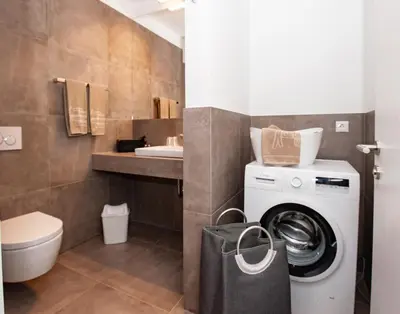 a bathroom with a washing machine and a sink at Modern Living by Nalserhof in Nalles