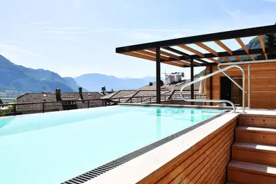 a swimming pool on the roof of a house with mountains at Modern Living by Nalserhof in Nalles