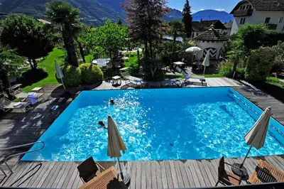 a pool at a hotel with two people swimming in it at Modern Living by Nalserhof in Nalles