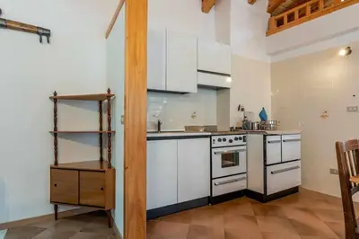 a kitchen with white cabinets and a stove at Dimora al Portico Cloz OSPITAR in Cloz