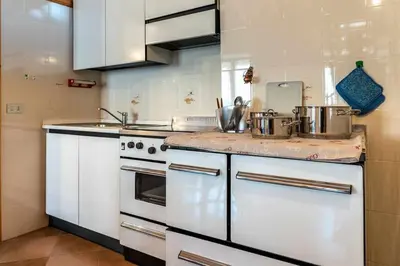 a kitchen with white appliances and a counter top at Dimora al Portico Cloz OSPITAR in Cloz