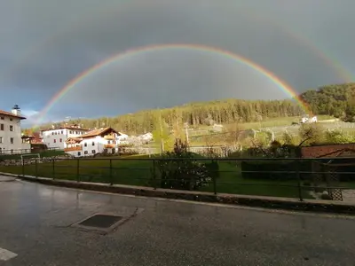 a rainbow in the sky over a field and a street at Agritur Fiore in Fondo
