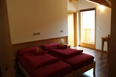 a bedroom with two beds with red pillows at Agritur Fiore in Fondo