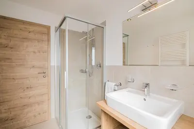 a bedroom with a large bed and a living room at Apartments Sosaslong in Selva di Val Gardena