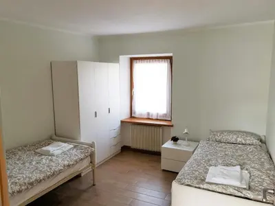 a bedroom with two beds and a window at Appartamento Rosina, per 4/6 persone. In centro in Coredo