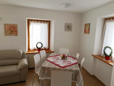 a living room with a table and a couch at Appartamento Rosina, per 4/6 persone. In centro in Coredo