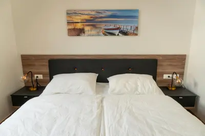 a bedroom with a white bed with two pillows at Ferienwohnung mit Garage, Fahrradraum und sehr großer sonnenverwöhnten Terrasse in Lagundo