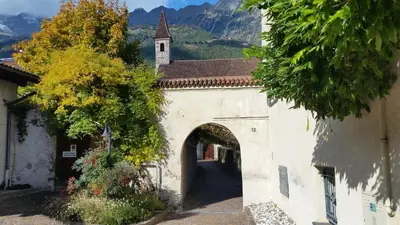 an archway leading to a building with a church at Ferienwohnung mit Garage, Fahrradraum und sehr großer sonnenverwöhnten Terrasse in Lagundo