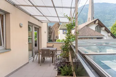 an outdoor patio with a table and chairs on a balcony at Ferienwohnung mit Garage, Fahrradraum und sehr großer sonnenverwöhnten Terrasse in Lagundo