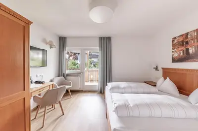 a hotel room with a bed and a desk at Hotel Oberwirt in Velturno