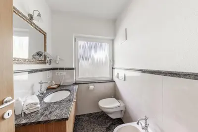 a bathroom with a sink and a toilet and a window at Hotel Oberwirt in Velturno