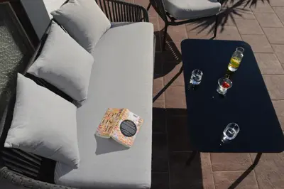 a white couch with a table with a glass of wine at Apartment Pyrus in Tirolo