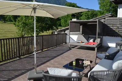 a patio with an umbrella and a table and chairs at Apartment Pyrus in Tirolo
