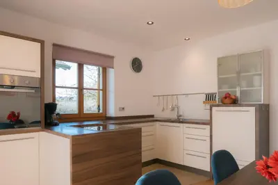 a kitchen with white cabinets and a wooden counter top at Apartment Pyrus in Tirolo