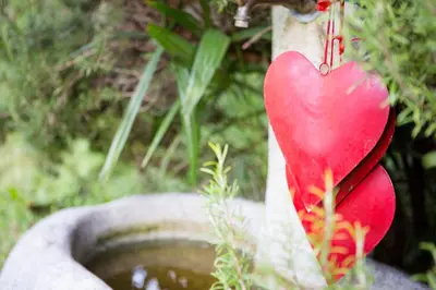 a heart shaped ornament hanging from a water fountain at Hotel Gruberhof in Merano