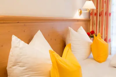 a bunch of pillows sitting on a bed at Hotel Gruberhof in Merano