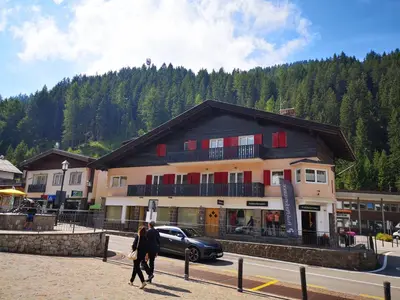 a couple of people walking in front of a building at Appartamento Angelo in Selva di Val Gardena