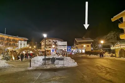 a street at night with a arrow pointing to a building at Appartamento Angelo in Selva di Val Gardena