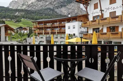 a table and chairs on a balcony with a view of a mountain at Appartamento Angelo in Selva di Val Gardena