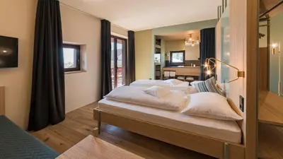 a bedroom with a bed with white sheets and pillows at Hotel Villa Mayr Rooms & Suites in Brixen