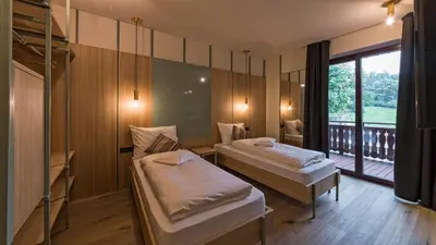 a room with two beds and a balcony at Hotel Villa Mayr Rooms & Suites in Brixen