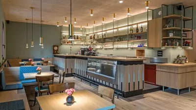 a restaurant with a bar and tables and chairs at Hotel Villa Mayr Rooms & Suites in Brixen