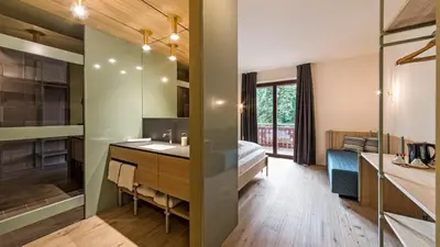 a bathroom with a sink and a bed in a room at Hotel Villa Mayr Rooms & Suites in Brixen