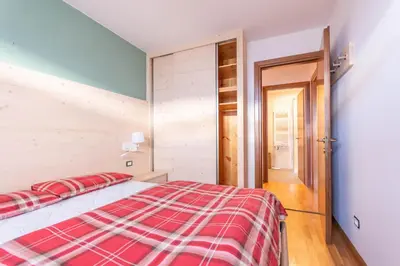 a bedroom with a bed with a red and white blanket at Casa Piz Meda in Soraga