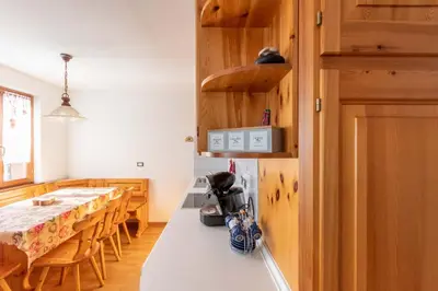 a kitchen and dining room with a white counter top at Casa Piz Meda in Soraga