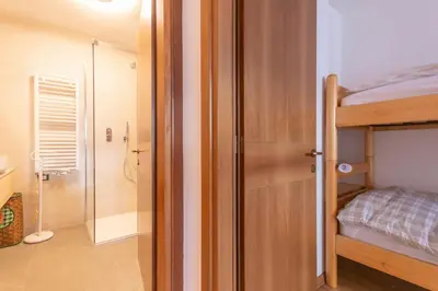 a bedroom with a bunk bed and a shower at Casa Piz Meda in Soraga
