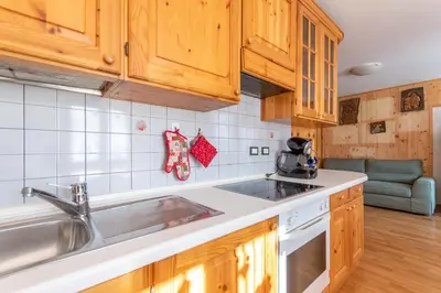 a kitchen with wooden cabinets and a sink at Casa Piz Meda in Soraga
