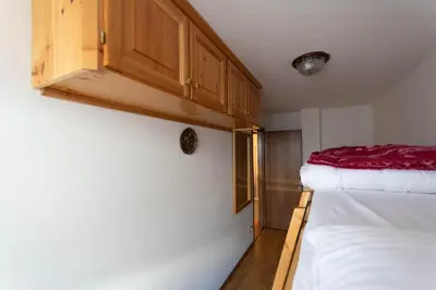 a small room with a bed and a cabinet at Casa Piz Meda in Soraga