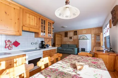 a kitchen with a table and a dining room at Casa Piz Meda in Soraga