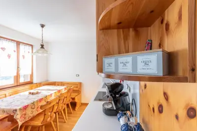 a kitchen and dining room with a table and chairs at Casa Piz Meda in Soraga