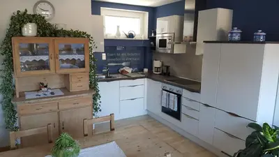 a kitchen with white cabinets and a stove top oven at viaDolceVita - Blaue Gästewohnung in Lana