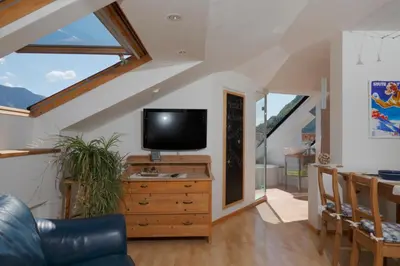 a living room with a tv on a wooden dresser at viaDolceVita - Blaue Gästewohnung in Lana