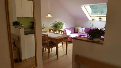 a living room with a table and a purple couch at viaDolceVita - Grüne Gästewohnung in Lana