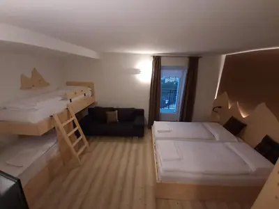 a small room with two bunk beds and a couch at B and B nonna Rosa vista Lagorai in Capriana