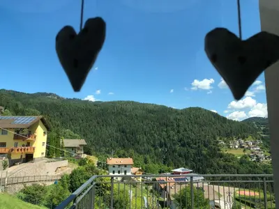 a view of a mountain with hearts hanging from a balcony at B and B nonna Rosa vista Lagorai in Capriana