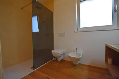 a bathroom with a toilet and a shower and a sink at Casa Alpina in Cavalese
