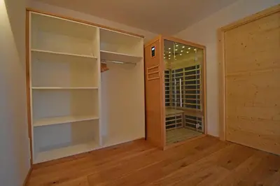a walk in closet with a glass door and a window at Casa Alpina in Cavalese
