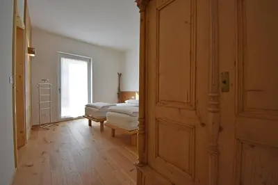 a room with a bedroom with a bed and a door at Casa Alpina in Cavalese
