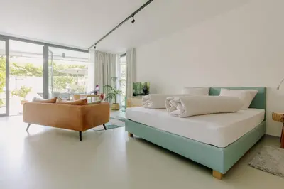 a bedroom with a bed and a couch in a room at La Villetta 17 - smarter Rückzugsort für die großen Winter-Wettkämpfe in Lana