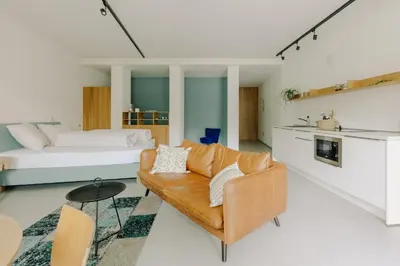 a living room with a couch and a bed at La Villetta 17 - smarter Rückzugsort für die großen Winter-Wettkämpfe in Lana