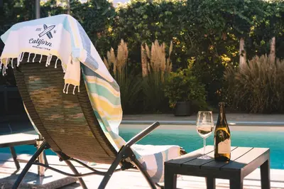 a chair with a bottle of wine and a table with a glass at CasaLuNa in Appiano sulla Strada del Vino