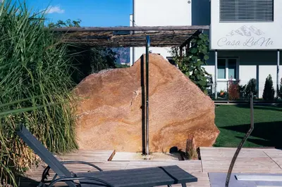 a bench sitting next to a large rock at CasaLuNa in Appiano sulla Strada del Vino