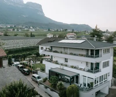 a white house with a solar array on the roof at CasaLuNa in Appiano sulla Strada del Vino