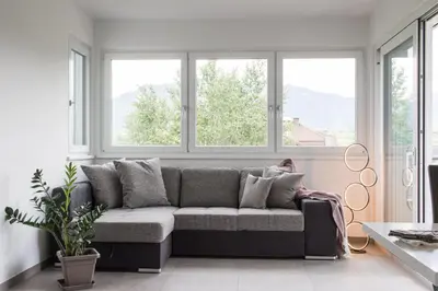 a couch in a living room with windows at CasaLuNa in Appiano sulla Strada del Vino